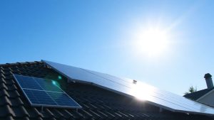 Panouri fotovoltaice pe acoperiș sub cerul albastru.